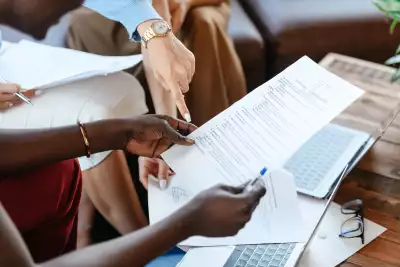 People pointing at a paper in office