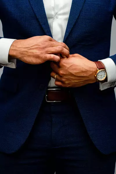 Suited man doing up button