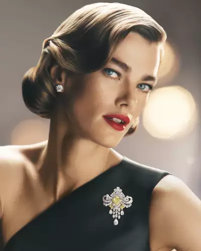 Model wears a brooch from the 'Jeweler to the Stars' chapter, with a 9.81-carat cushion-cut fancy intense yellow diamond centre stone is surrounded by an elaborate arrangement of 12.74 carats of diamonds