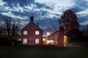 A timber-clad extension with ribbon windows offers sympathetic visual contrast in this design from Holland Green