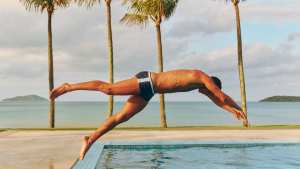 Model diving into a pool wearing Frescobol Carioca swimshorts