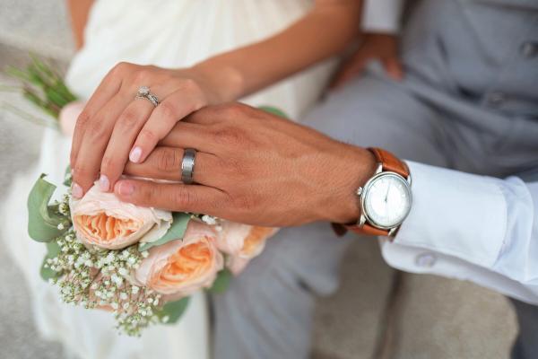 Close-up of a bride and groom's hands getting married