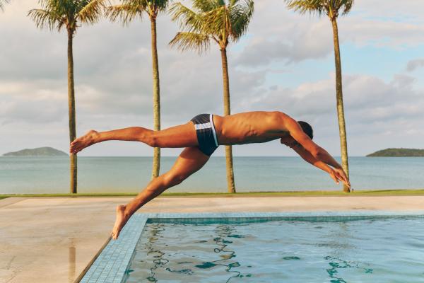 Model diving into a pool wearing Frescobol Carioca swimshorts