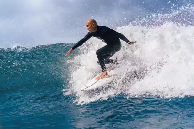 Kelly Slater riding the waves wearing a Breitling Superocean 'Kelly Slater'