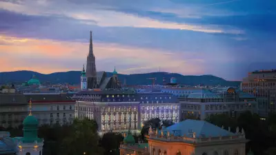 A warm light casts its glow as the sun sets over the Almanac Palais hotel in Vienna.