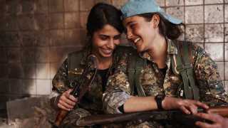 Silava and Berivan share a laugh in an abandoned ISIS base