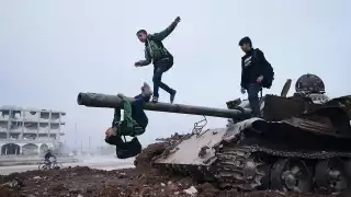 Amude, Memo, and Salar play on a destroyed ISIS tank after school