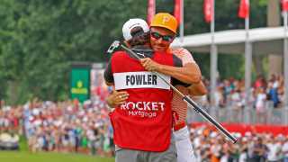 PGA golfer Rickie Fowler gets a hug from his caddie Ricky Romano on the 18th green after winning in a 3 way playoff on July 2, 2023, during the final round of the Rocket Mortgage Classic at the Detroit Golf Club in Detroit, Michigan.