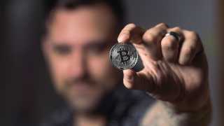 Man holding up bitcoin