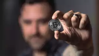 Man holding up bitcoin