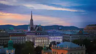 A warm light casts its glow as the sun sets over the Almanac Palais hotel in Vienna.