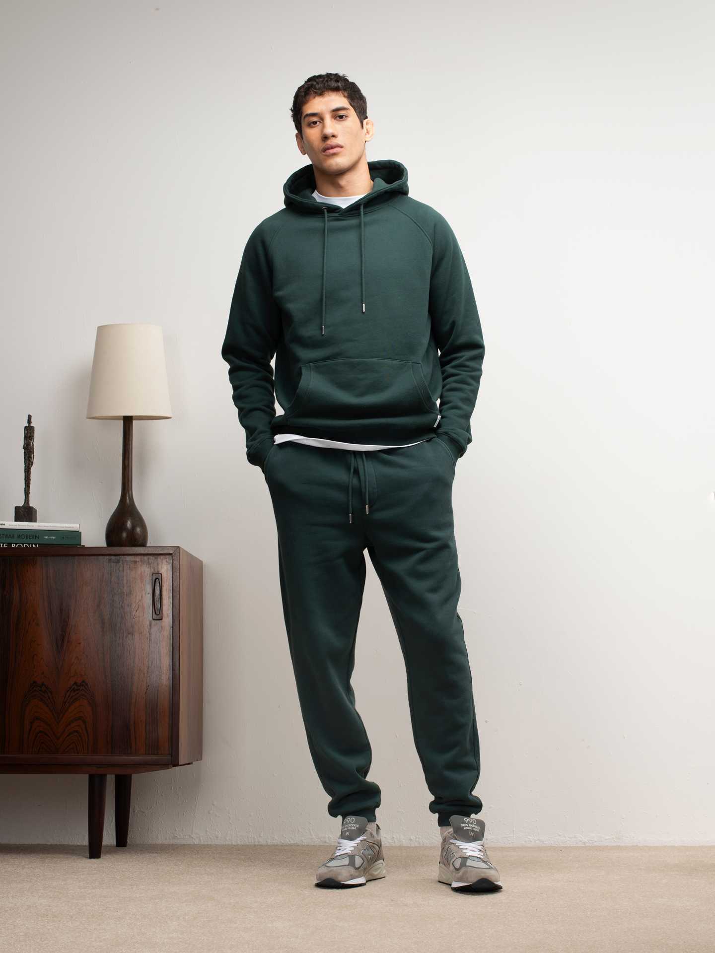 Hamilton & Hare model wears pullover hood track pant in gate green, priced £165 and £130 respectively.