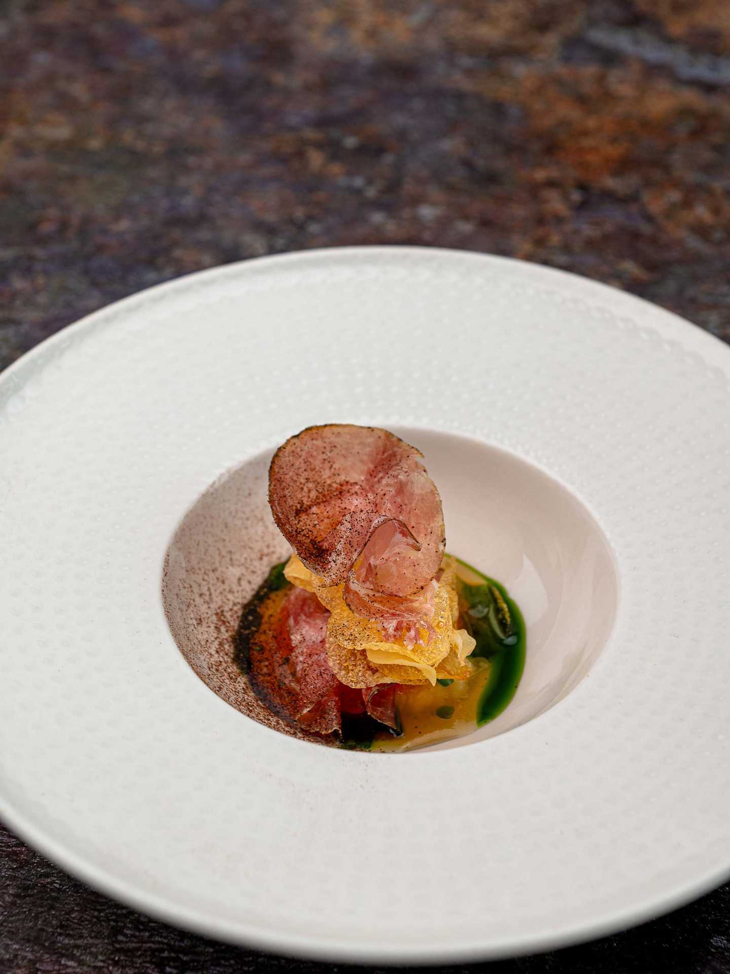 Slow-cooked Copper Maran egg with aged ham, sour cream, and parsnip flakes