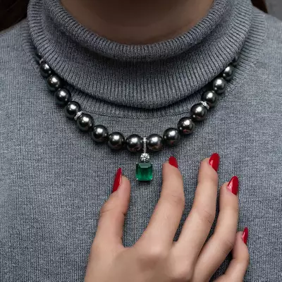Lot 171: a single row of peacock-coloured Tahitian cultured pearls with an emerald and diamond pendant estimate, &pound;4,000-&pound;6,000.