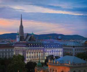 A warm light casts its glow as the sun sets over the Almanac Palais hotel in Vienna.