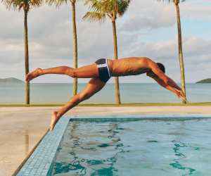 Model diving into a pool wearing Frescobol Carioca swimshorts